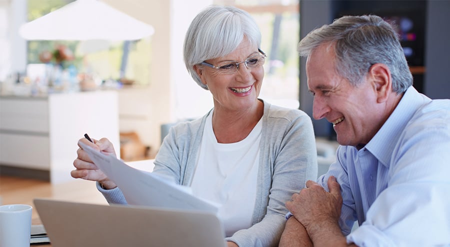  A smiling freelancer couple reviews their finances and sets service rates for early retirement.